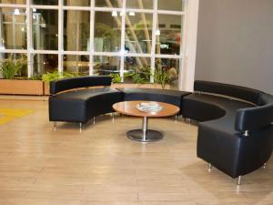 a waiting room with black chairs and a table at Ibis Mossoro in Mossoró