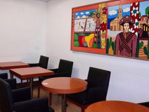 a room with tables and chairs and a painting on the wall at Ibis Mossoro in Mossoró +70 photos