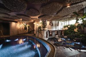 a swimming pool in a room with a house at Wellnesshotel Der Engel - Tannheimer Tal in Grän