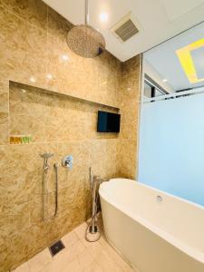 a bathroom with a tub and a glass shower at Dorsett Residence KL in Kuala Lumpur