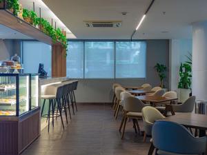 um restaurante com mesas e cadeiras e um balcão em Novotel RJ Santos Dumont no Rio de Janeiro