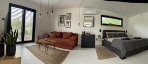 Un dormitorio con una cama, un sofá y una mesa. en Danube Cottage, en Komárno