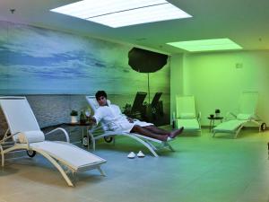 a woman sitting on a chair in a room with chairs at Novotel RJ Santos Dumont in Rio de Janeiro