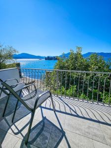 a chair on a balcony with a view of the water at Casa dei Cigni in Cannobio