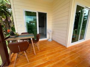 a porch with a table and chairs and a fan at Billabong Village in Ko Phangan