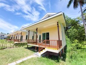a small yellow house with a porch at Billabong Village in Ko Phangan