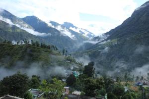 a town in a valley with mountains in the background at Mount Holiday Pahadi Home Stay in Gupta Kāshi +8 photos