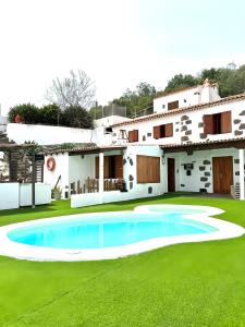 a house with a swimming pool in the yard at Ohana Villa Paula in Huertas del Palmar