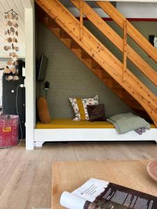 a bench under a stairs with pillows on it at Hidden Gem By Thy National Park in Bedsted