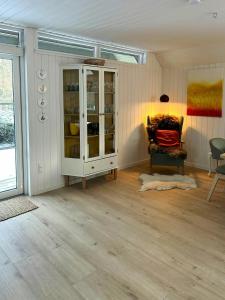 a living room with a glass cabinet and a chair at Hidden Gem By Thy National Park in Bedsted +25 photos