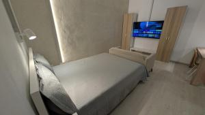 Las PuntasにあるMiniLoft La Ballena AC, Vistas y Parkingのベッドとテレビのある小さな寝室