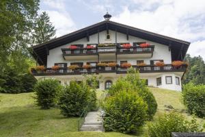 una casa en una colina con flores en el balcón en Bergschlössl - Eckwohnung 24, en Oberaudorf