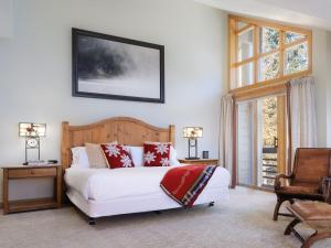テトン・ビレッジにあるRMR: Tram Tower 12 Condo in Teton Villageのベッドルーム(白いベッド、赤い枕付)