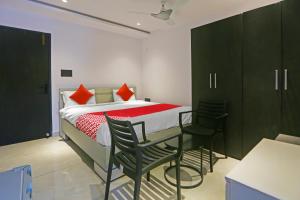 a bedroom with a bed with black cabinets and chairs at Super Hotel O Botcha Convection in Visakhapatnam +25 photos