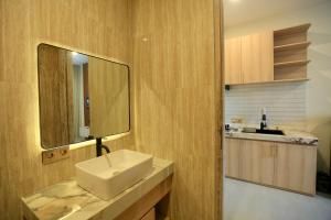 un baño con lavabo y espejo en Luminera Bali Apartment, en Nusa Dua