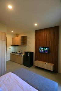 Habitación con cama y cocina con TV. en Luminera Bali Apartment, en Nusa Dua
