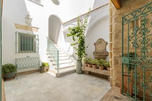 a hallway with stairs and a gate with potted plants at La Casa de la Plaza del Arroyo - Traditional Luxury in Jerez in Jerez de la Frontera