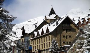 un edificio cubierto de nieve con una montaña en el fondo en Snö Villa de Sallent 4, en Formigal