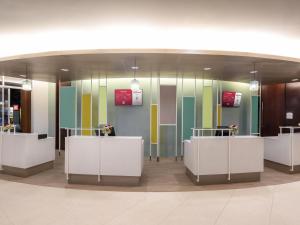 a lobby with colorful glass walls and white counters at Ibis Phuket Patong in Patong Beach