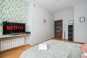 ワルシャワにあるLumina Apart near Palace of Cultureのベッドとテレビのあるリビングルーム