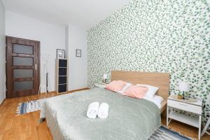 ワルシャワにあるLumina Apart near Palace of Cultureのベッドルーム1室(白い靴2本付きのベッド1台付)