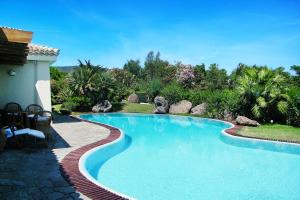 a large swimming pool in a yard with a house at Villa Flor, Exclusive House with Pool in Stintino in Stintino
