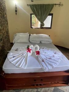 En eller flere senge i et værelse på Emanyatta Lodge