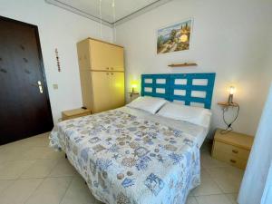 a bedroom with a bed with a blue head board at Comfy flat for four-Beahost in Porto Santa Margherita di Caorle