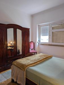 een slaapkamer met een bed, een dressoir en een stoel bij Charming D'Ourique 3-Bedroom Apartment with Private Balcony in Central Campo de Ourique, Lisbon in Lissabon +61 foto's
