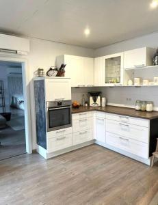a kitchen with white cabinets and a stove top oven at Ferienhaus Loreleyresidenz Kestert in Kestert