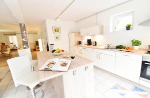 a kitchen with white cabinets and a wooden table at Fördequartier Stadtloft Flensburg in Flensburg +35 photos