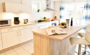 a kitchen with a wooden island with a newspaper on it at Fördequartier Stadtloft Flensburg in Flensburg