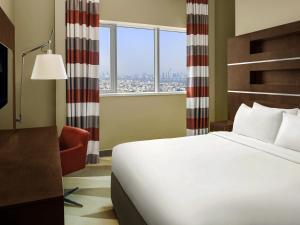 a hotel room with a bed and a window at Novotel Dubai Al Barsha in Dubai +141 photos