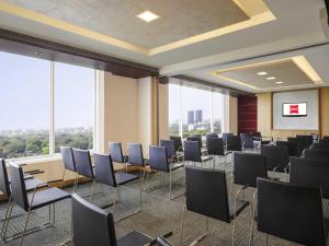 a conference room with chairs and a projection screen at ibis Pune Viman Nagar - An Accor Brand in Pune
