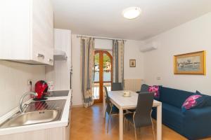 a kitchen and living room with a blue couch and a table at La Casa in Gallura primo piano in Calangianus +9 photos