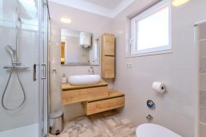 a bathroom with a sink and a toilet and a shower at Apartmani Enna in Mali Lošinj +92 photos