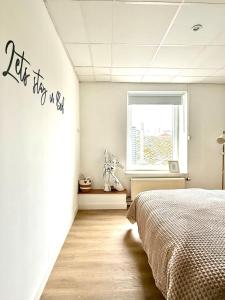 a bedroom with a bed and a window at Spacious duplex in the center of Bastogne Onikos rooms in Bastogne