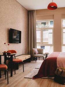 a bedroom with a bed and a table and chairs at Saint J Hotel by Brassbell in Cairo