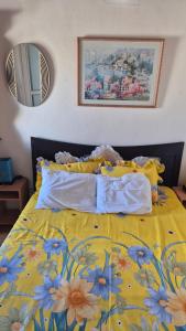 Una cama con una manta amarilla con flores. en Romantic Escapade, en Flic en Flac