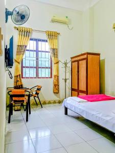 a bedroom with a bed and a table and a chair at Nhà Nghỉ Việt Hùng in Ba Be