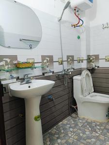 a bathroom with a sink and a toilet at Nhà Nghỉ Việt Hùng in Ba Be +9 photos