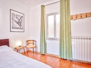 une chambre avec un lit, une chaise et une fenêtre dans l'établissement Bright Finalborgo Apartment, à Finale Ligure