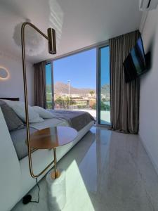 une chambre avec un lit et une table et une grande fenêtre dans l'établissement New Villa Los Olivos, à Adeje
