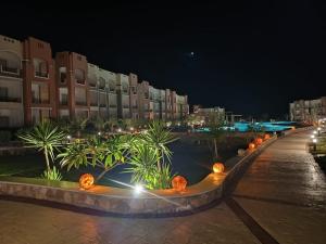 a resort at night with palm trees and buildings at Oyster Bay Beach suits in Marsa Alam