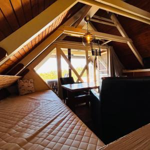 a room with a bed and a table and a window at Pfahlbau Sunset I Toplage Elektroboot inklusive in Rust