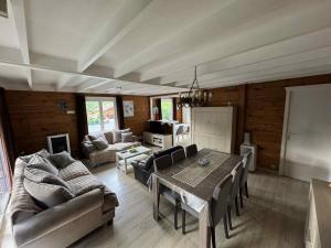 a living room with a table and a dining room at Chalet Dennerust in Durbuy