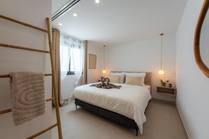 a bedroom with a bed with a stuffed animal on it at Luxury Villa - Sunset Rooftop - Heated Pool - Outdoor Kitchen - Airconditioned in Palm-Mar +44 photos