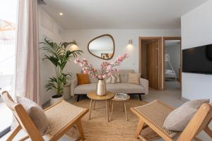 a living room with a couch and a table with flowers at Luxury Villa - Sunset Rooftop - Heated Pool - Outdoor Kitchen - Airconditioned in Palm-Mar