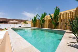 a swimming pool in front of a building at Luxury Villa - Sunset Rooftop - Heated Pool - Outdoor Kitchen - Airconditioned in Palm-Mar