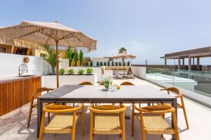 an outdoor patio with a table and chairs at Luxury Villa - Sunset Rooftop - Heated Pool - Outdoor Kitchen - Airconditioned in Palm-Mar